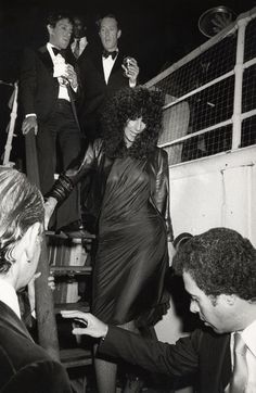 an old black and white photo of people dressed in tuxedos on a boat