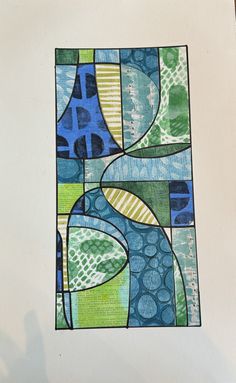 an abstract painting with blue, green and yellow colors on white paper next to a black pen