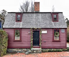 a red house with wreaths on the door and windows