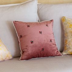 the pillows on the couch are all different colors and patterns, but one is pink