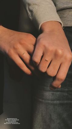 a person with their hand on the other side of his arm, wearing a ring