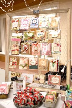 a table topped with lots of cards next to a wall covered in pictures and decorations