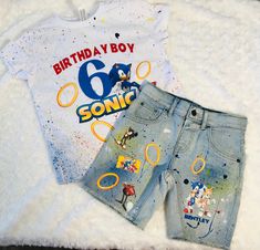 Sonic Birthday outfit with scattered paint splats and sonic images **Can make any character / theme ** PLEASE READ ALL DETAILS Please note that all outfits are processed within 10-12days then it's ship out. I am unable to send out any earlier then when I can, But You do have an options to choose an earlier shipping date if need to . Thank you for your time Send a message with full details *Size Of shirt and jeans or shorts *Color Of shirt *jeans or shorts *Color of words or lettering *what speci Sonic 2 Birthday Shirt, Sonic Birthday Family Shirts, Sonic Hedgehog Birthday Shirts, Sonic Rings Party, Sonic Birthday Shirt Ideas, Boy Birthday Outfit Ideas, Sonic Outfit Ideas, Sonic Centerpieces Birthday Parties, Sonic The Hedgehog Birthday Shirt