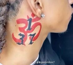 a woman with red and black ink on her neck has an omen symbol painted on it