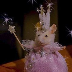 a mouse in a pink dress with stars on it's head and a wand