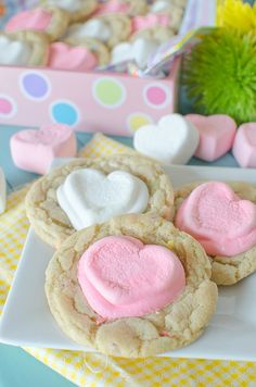 cookies with marshmallows in the shape of hearts on a plate next to other treats