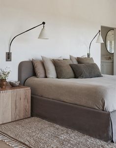 a bedroom with a bed, two lamps and a rug in front of the bed