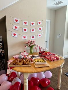 a table topped with lots of food and balloons