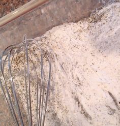 a metal whisk in a bowl filled with flour