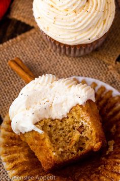 two cupcakes with white frosting and cinnamon sticks