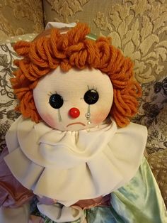 an orange haired doll sitting on top of a couch