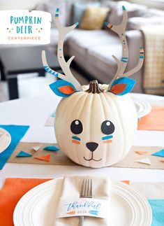 a white pumpkin with antlers on it sitting on top of a dining room table