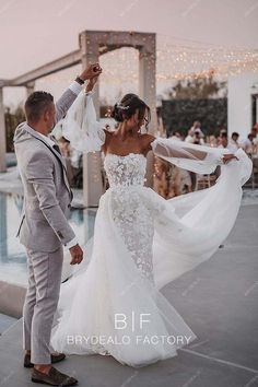 the bride and groom are dancing by the pool