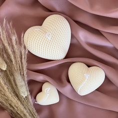 three heart shaped soaps sitting on top of a pink cloth