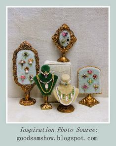 an assortment of jewelry on display in front of a white background with gold trimmings