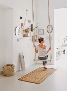 a woman on a swing in a white room