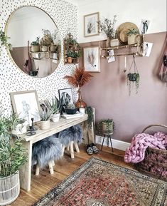 a room filled with lots of plants and pictures on the wall above a wooden table