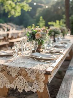 an outdoor table set with place settings and lace doily on the tablecloths