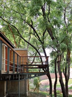 the tree house is surrounded by trees and has a deck that extends to it's second floor