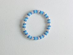 a blue and white beaded bracelet sitting on top of a table