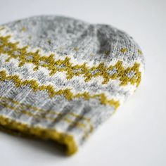 a gray and yellow hat sitting on top of a white table