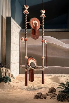 an artistic sculpture in the middle of a desert with rocks and sand behind it,