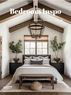 a bed room with a neatly made bed next to a window and potted plants