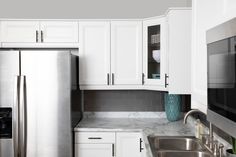 a kitchen with stainless steel appliances and white cabinets