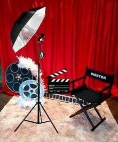 a chair and umbrella sitting on top of a white rug next to a red curtain