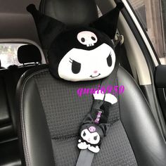 a black and white cat sitting in the back seat of a car with skulls on it