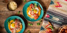 two bowls filled with food sitting on top of a wooden table next to an egg