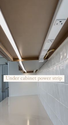 the under cabinet power strip is installed in an empty room with white walls and tile flooring