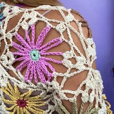 the back of a woman's top with crocheted flowers on it,