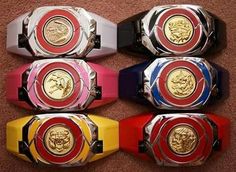 four different colored wrist watches sitting on the floor