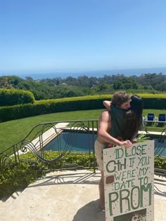 a man and woman kissing in front of a sign that says i'd lose what if you were my prom prom