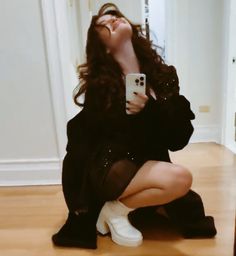 a woman sitting on the floor taking a selfie