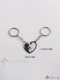 a heart shaped keychain with a black and white silhouette of a woman inside it