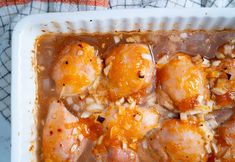 a white plate topped with chicken and rice covered in gravy on top of a table