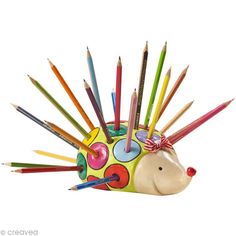 a toy hedgehog with colored pencils on it's head