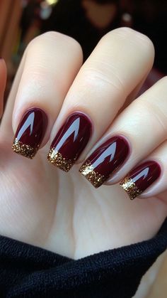 Burgundy with Gold Glitter Tips nails offer a luxurious blend of deep burgundy with sparkling gold tips, perfect for a sophisticated fall look. This design adds a touch of glamour and elegance to your autumn style. Click the pin and follow us for more fall nail inspiration! #BurgundyAndGold #FallNails #GlitterTips #AutumnStyle #NailInspiration Burgundy Nails With Gold Tips, Burgundy And Gold Nails Short, Fall Ideas Nails, Red Nails Gold Tips, Burgundy Gold Nail Designs, Burgundy Nails With Gold Glitter, Burgundy And Gold Nail Designs, Burgundy Winter Nails, November Manicure