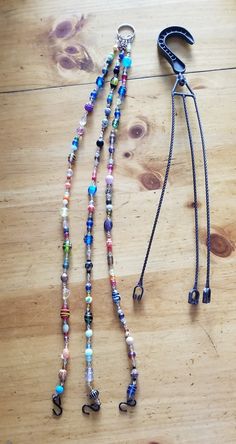 two lanyards on a wooden table with a leash attached to one end and beads hanging from the other side