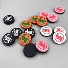 several different colored buttons sitting on top of a gray surface with black and orange patches