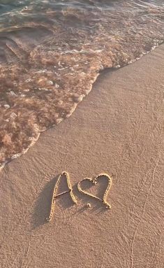 two hearts drawn in the sand at the beach