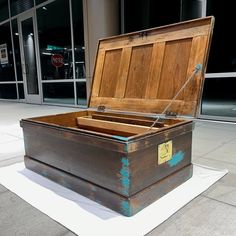 an open trunk sitting on the ground in front of a building with no people around it