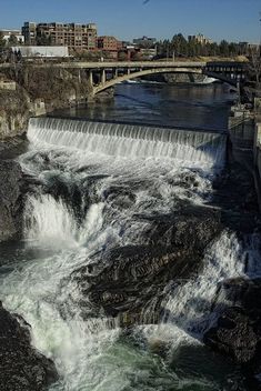 the water is running down the side of the falls and into the river below it