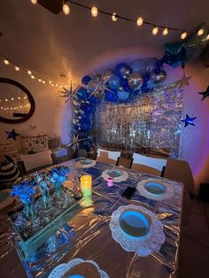 a dining room table set with blue and silver decorations