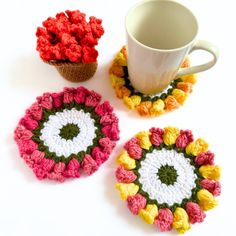 three crocheted coasters and a coffee cup on a white table with a mug in the middle