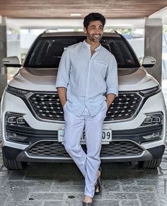 a man standing next to a white suv