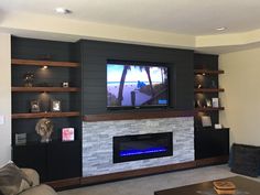 a flat screen tv mounted to the side of a wall next to a fire place