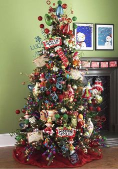 a decorated christmas tree in front of a fireplace